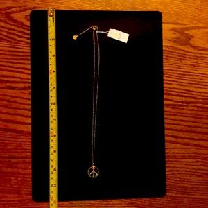 Kendra Scott gold chain and obsidian peace sign pendant